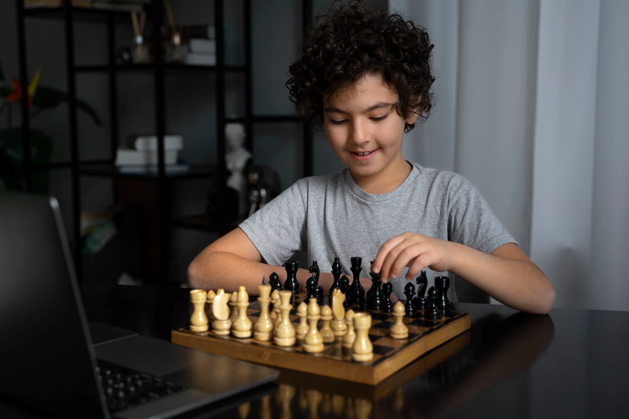 A young student smiling as he plays chess